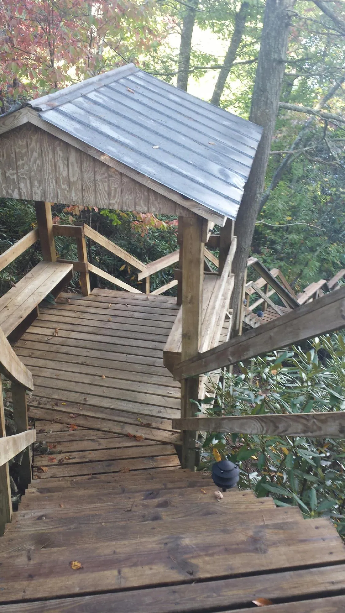 Metal roofed shelter over wooden steps on a wooded walkway — Skylight Repair & Installation work by our crew in West Yarmouth