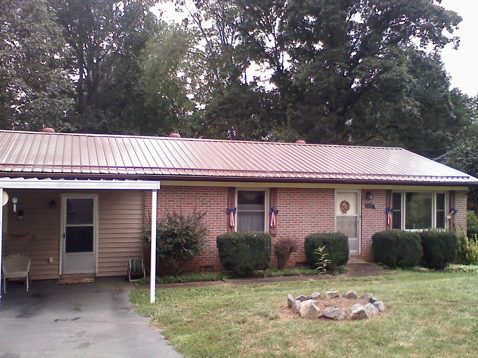 Bronze metal roof and carport on a brick ranch home — Roof Repair work by our crew in West Yarmouth